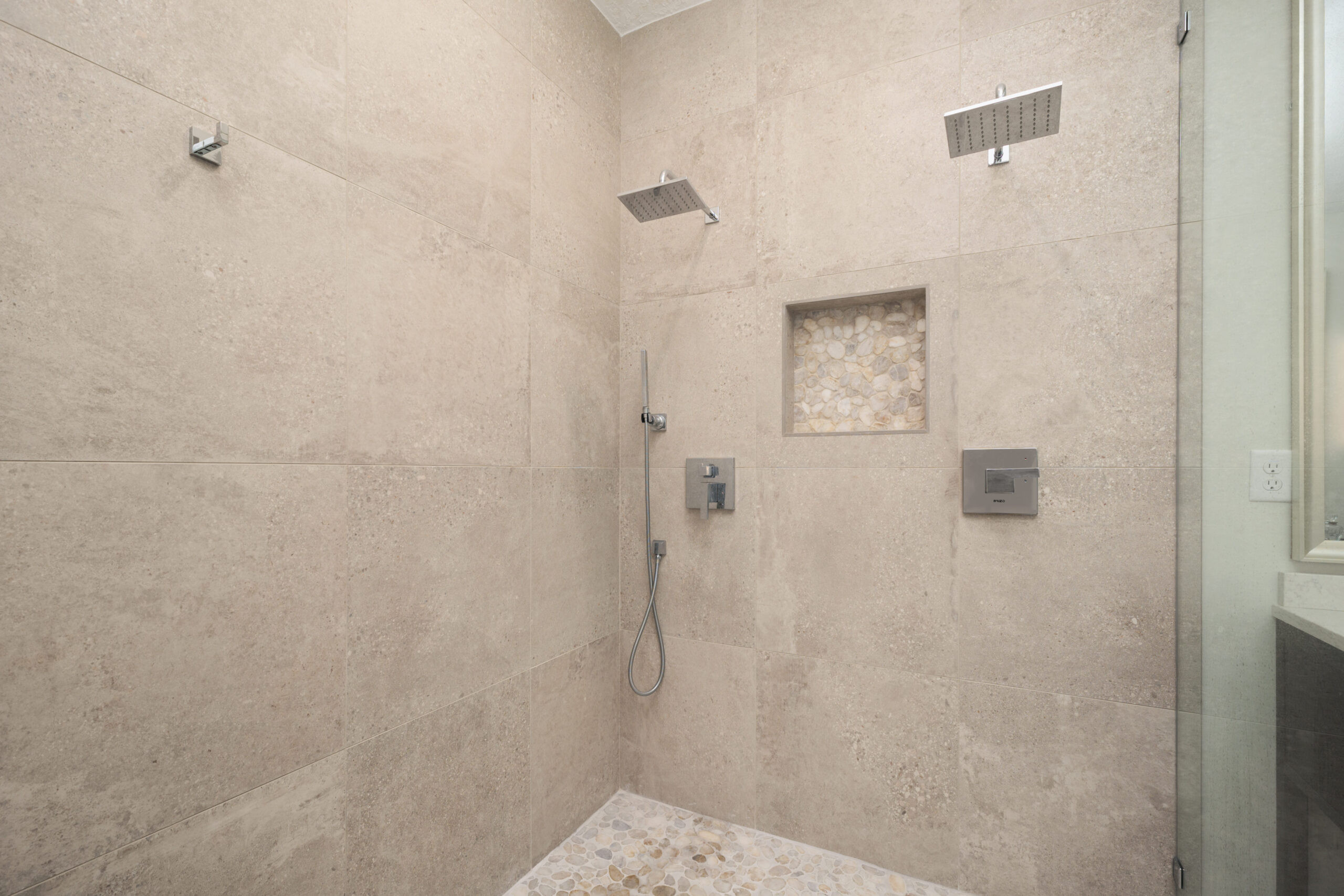 Shower enclosure with tiles all the way to the ceiling and two shower heads for a spa-like feel