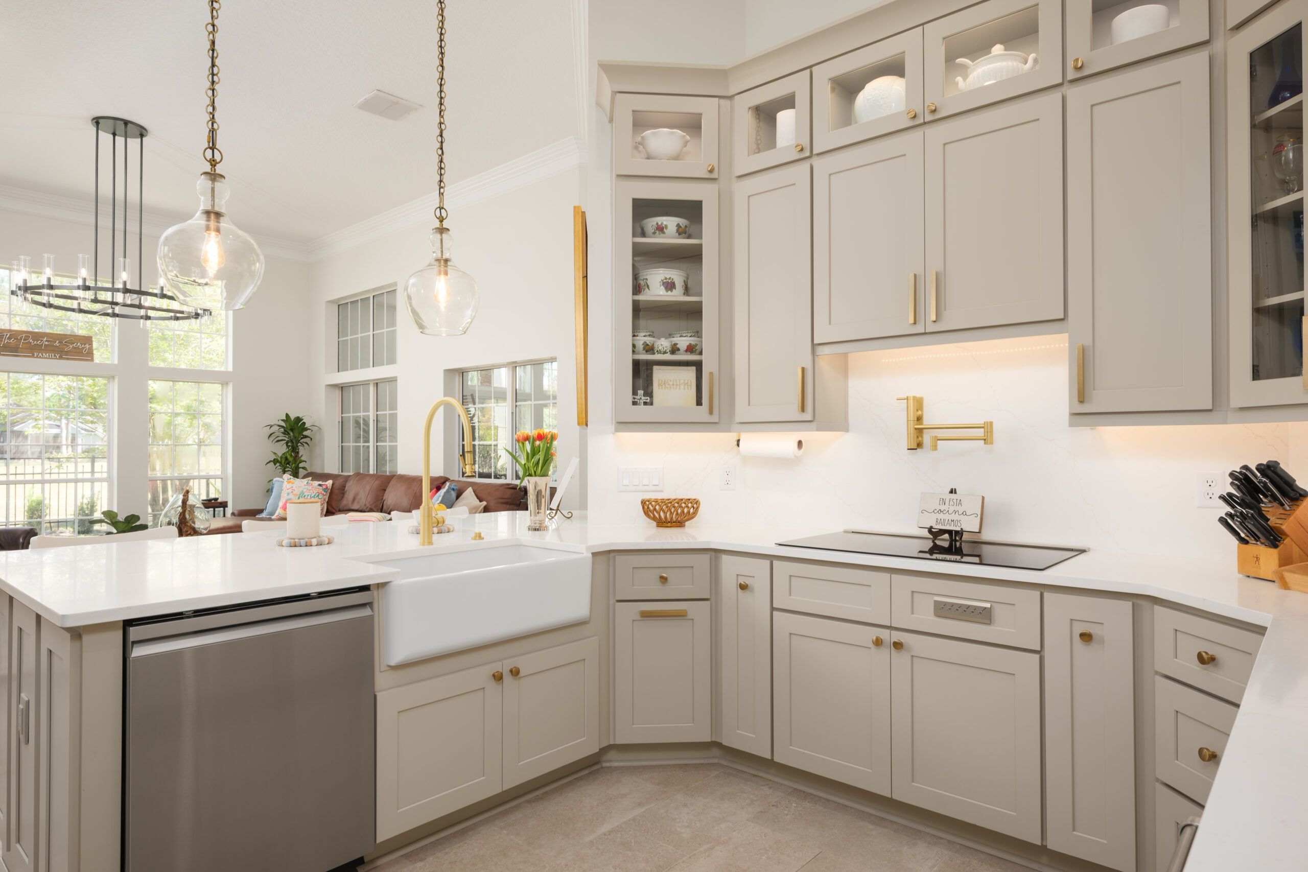 Kitchen remodel with sand colored cabinets, gold fixtures, and a white barn house sink
